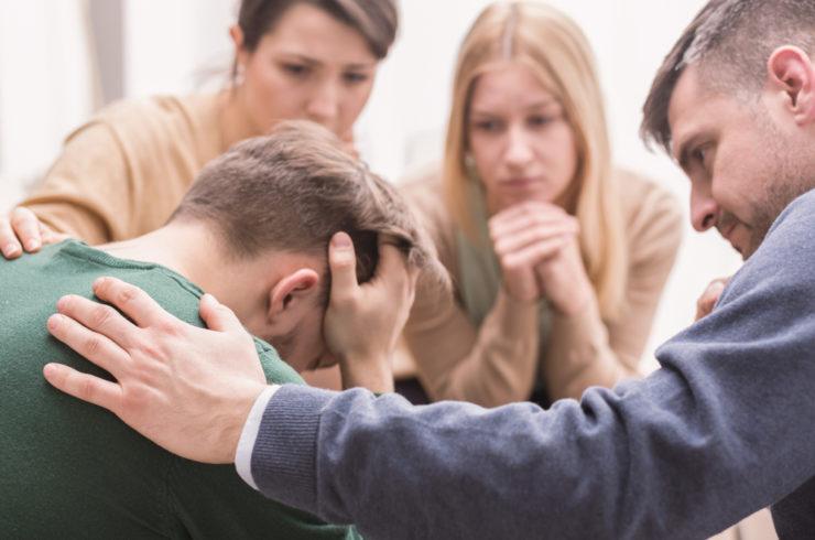 distressed man attends group therapy session