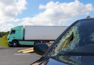 car with cracked windshield and truck in foreground