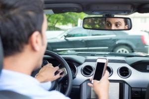 A man looks at his phone after a wreck