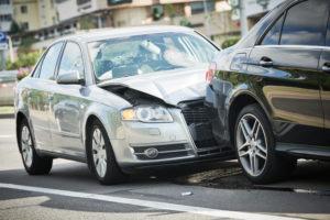 A rear-end collision causes damage to two cars.