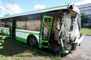 Green bus damaged after a collision.