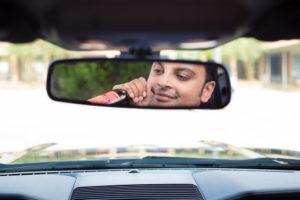 guy in rearview mirror drinking and driving