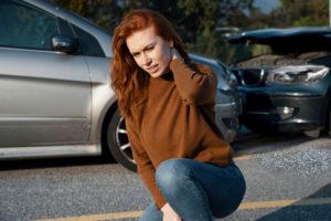 a woman gripping her neck after a car accident