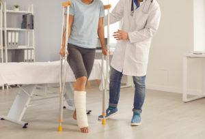 doctor helps patient with broken leg