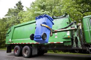 garbage truck lifting a garbage can