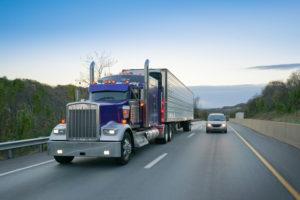 18-wheeler truck on highway next to passenger vehicle