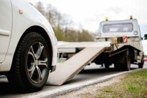 disabled car is loaded onto tow truck