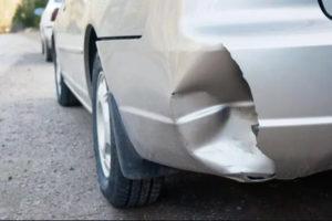 car with dented and cracked rear bumper