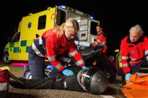 paramedics assist injured motorcyclist after accident