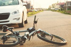 bike in the road by a car