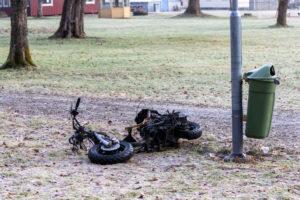 burnt abandoned moped on ground