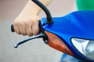 close-up of driver’s hand on moped