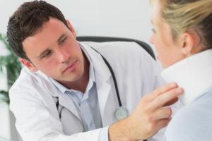 doctor examining patient’s neck