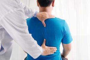 doctor helping patient with back pain