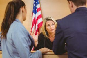 Two lawyers talk to a judge in court.