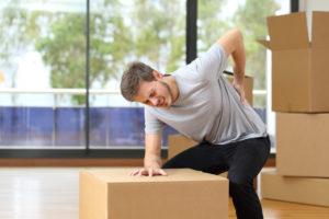 man with a backache moving boxes