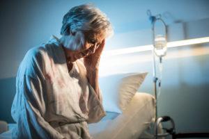 old woman holding her head in a hospital