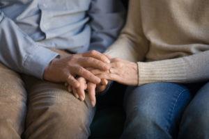 Two elderly people comfort each other.