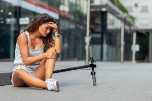 woman sitting on the curb after scooter accident