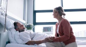 woman visiting husband in hospital bed