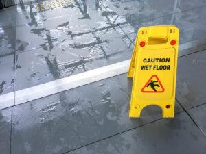 Caution: Floor is Wet' sign, emphasizing the importance of legal help for slip and fall accident victims